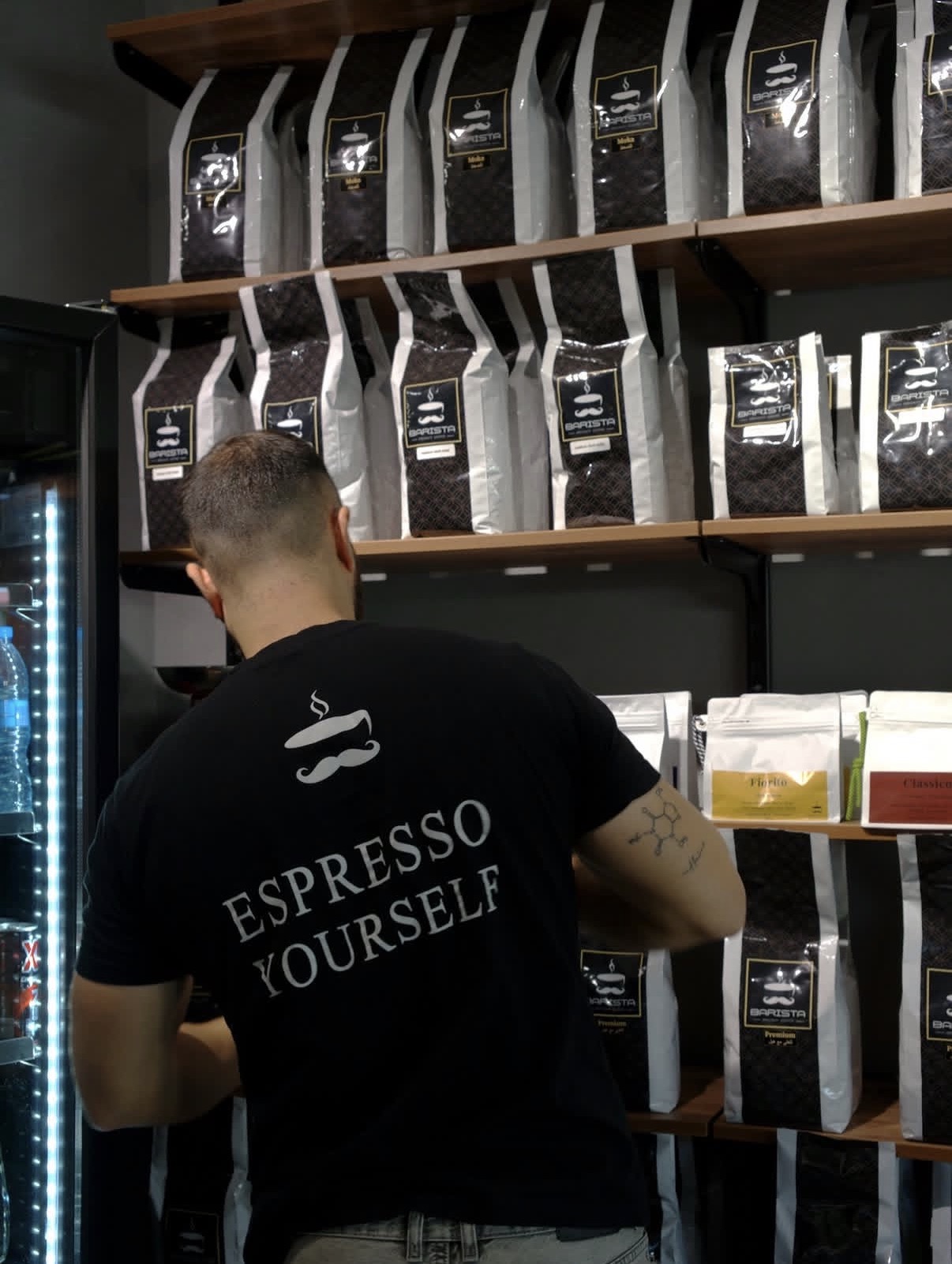 Barista team member stocking shelves of freshly roasted Barista coffee bags